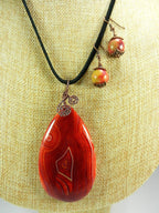 Orange Red Yellow and Cream Banded Agate Teardrop Gemstone Pendant with an Antique Copper Wire Wrapped Bail with Matching Agate Earrings and A Black Suede Necklace